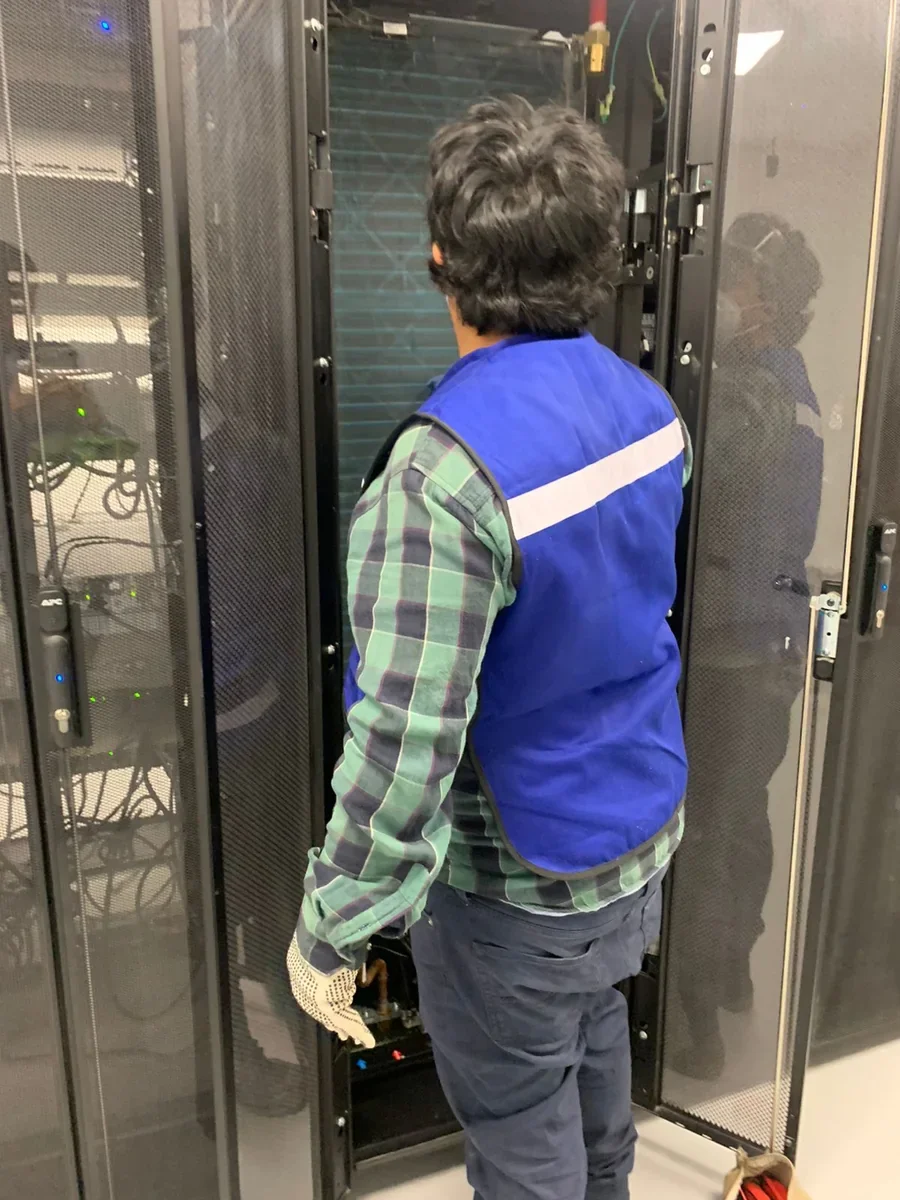 Técnico de Refrigeración y Sistemas dando mantenimiento a una unidad de enfriamiento de precisión en un centro de datos
